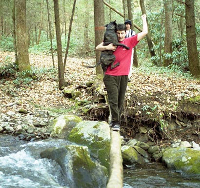 William carries Buster across a log in the Smokies