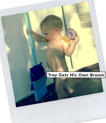 naked baby runs with toy broom and sippy cup in hand